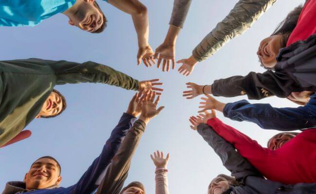 Equipe unindo mãos, representando colaboração e estratégias conjuntas para monetizar no Instagram
