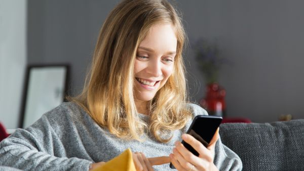 Mulher sorrindo usando Instagram no celular sem problemas de funcionamento
