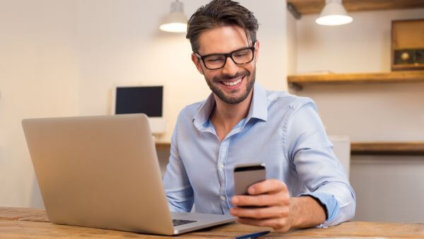 Homem sorrindo enquanto trabalha no laptop. Nomes para instagram masculino