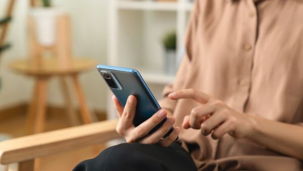 Mulher segurando um smartphone e navegando na internet e vendo como aumentar o tempo do story.