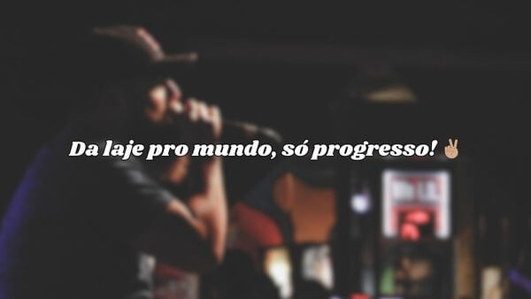 Rapper se apresentando no palco com a frase "Da laje pro mundo, só progresso!" sobreposta.