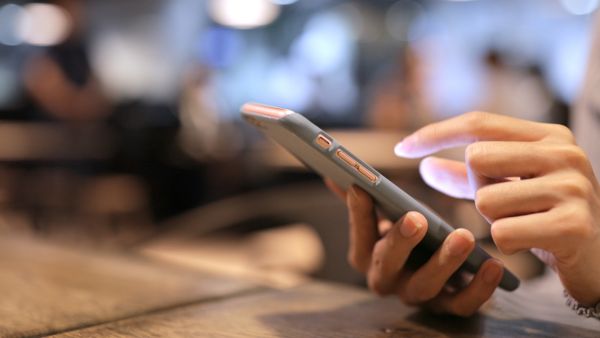 Mulher assistindo vídeos no Instagram em ambiente interno público